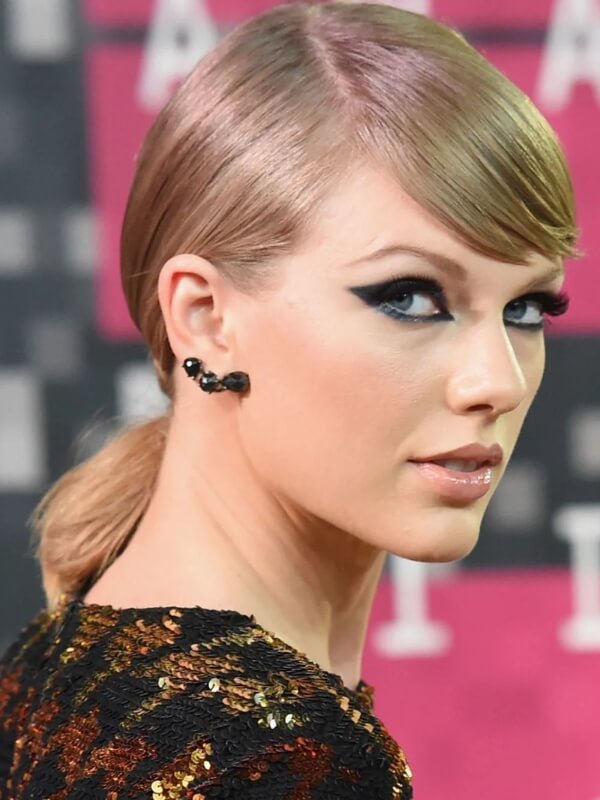 Taylor elevates the slicked-back look with an off-center part