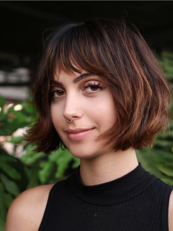 This bob haircut features a rounded shape, framing the face in a soft and flattering manner