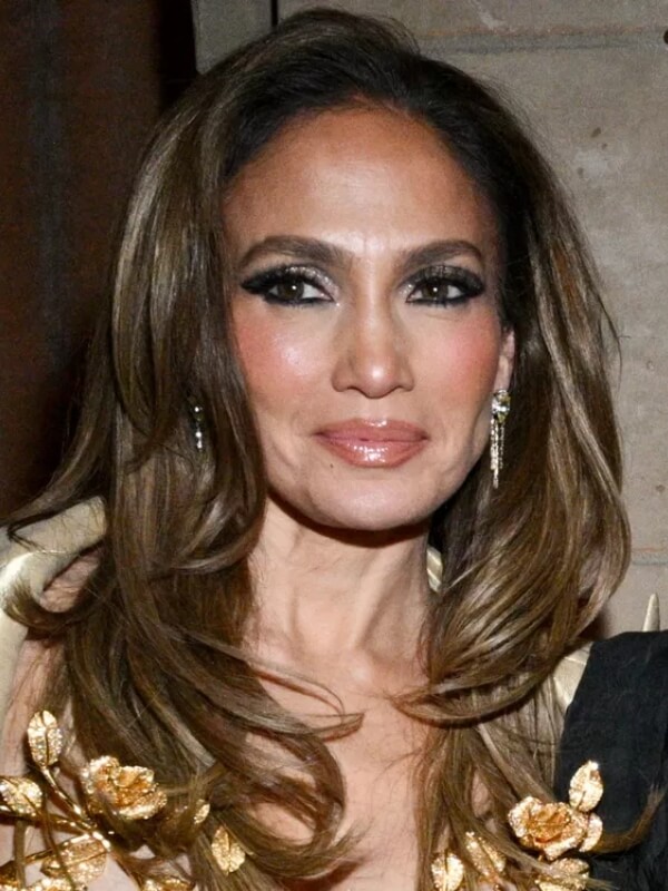 Jennifer Lopez wears a side-parted, face-framing style that adds softness to her face