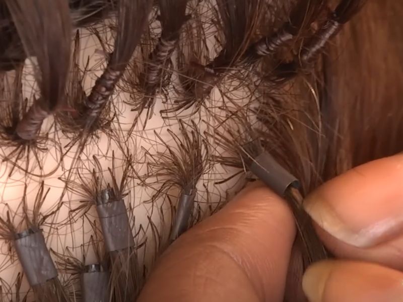 Slide the keratin tip extension onto the threaded section of hair